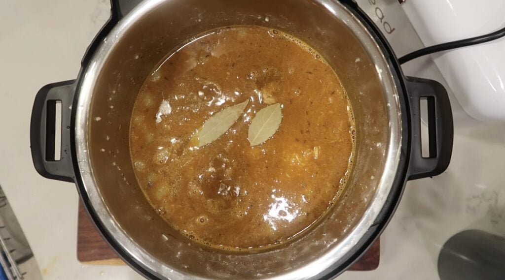 Adding bay leaves on top of broth